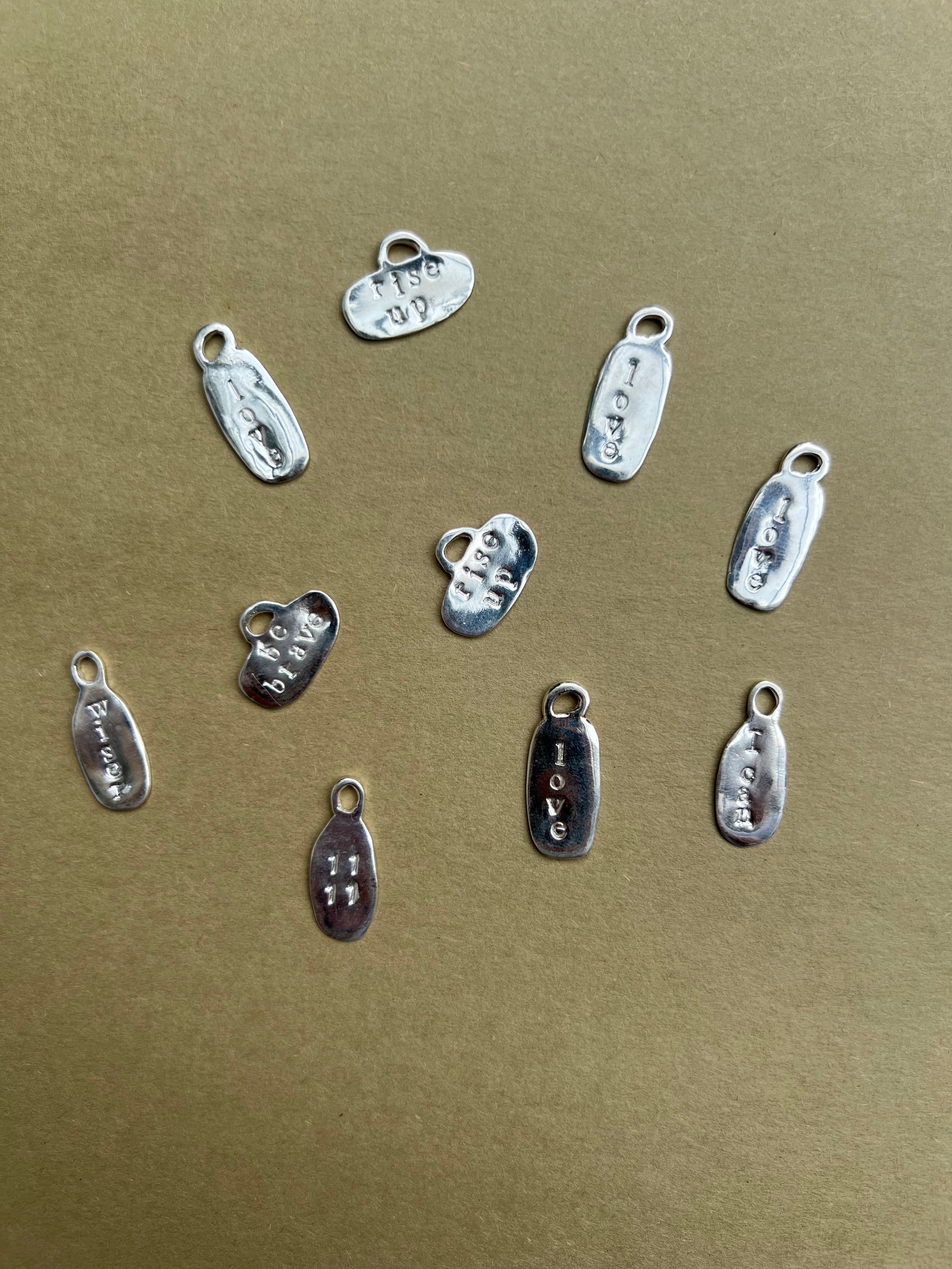 Cadena de cuero con charms EmpowerWord de Laveleza, con colgantes de palabras motivadoras y detalles en plata.