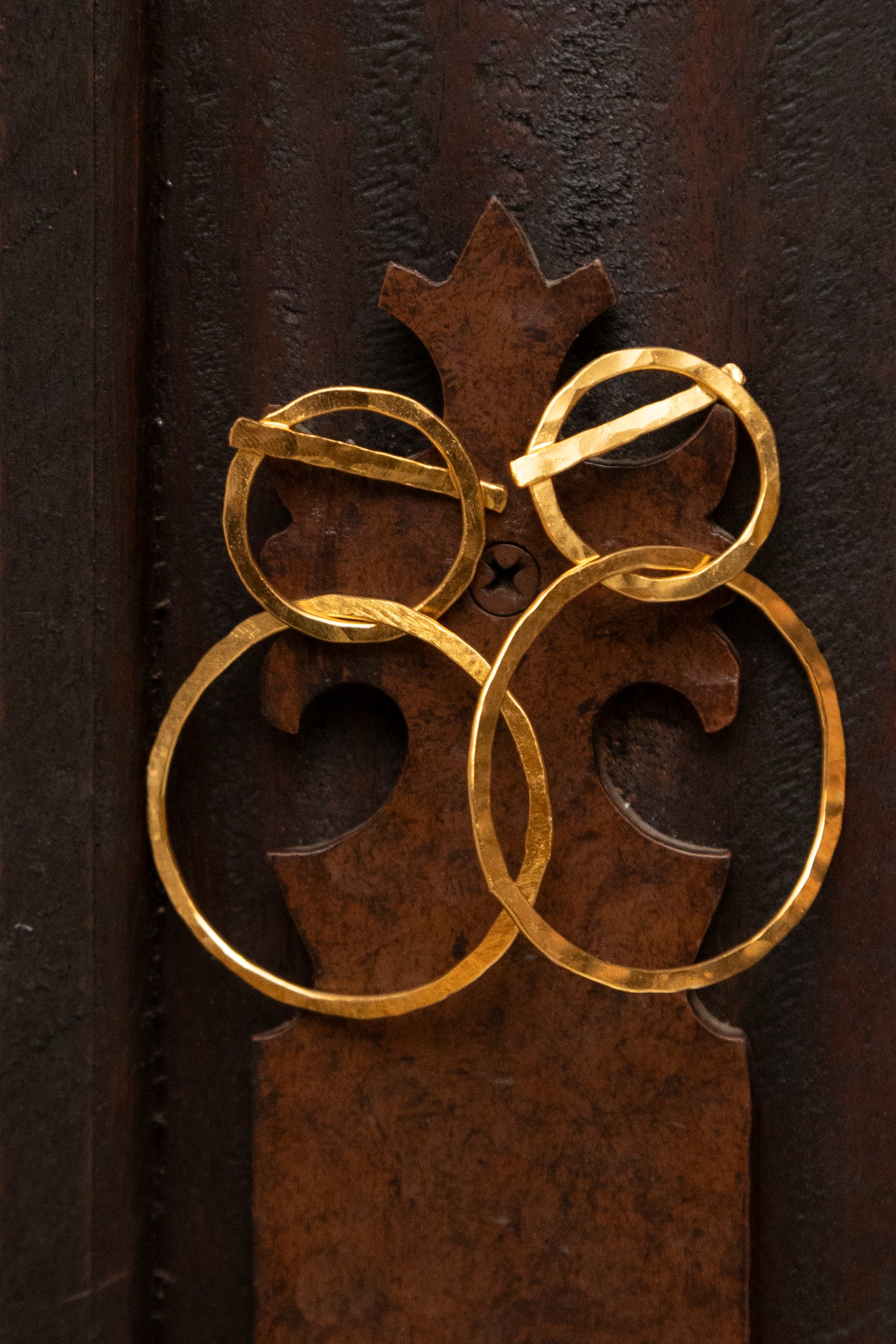 Candongas livianas Amanecer de Laveleza, aretas elegantes en diseño de aro forjado de bronce y baño en oro.